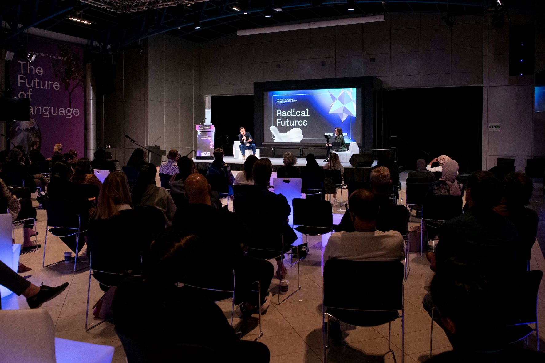 3. Eyal Weizman, (left, On Stage) The Keynote Speaker At Tasmeem Doha 2022, Taking Questions From The Audience. Image Courtesy Raviv Cohen. 