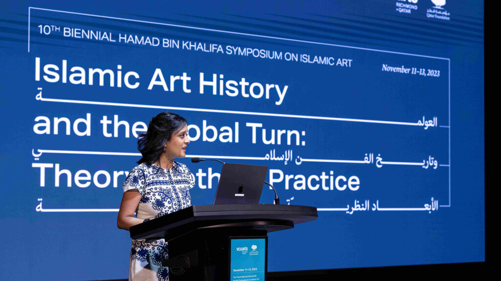 Radha Welcoming People To The Symposium