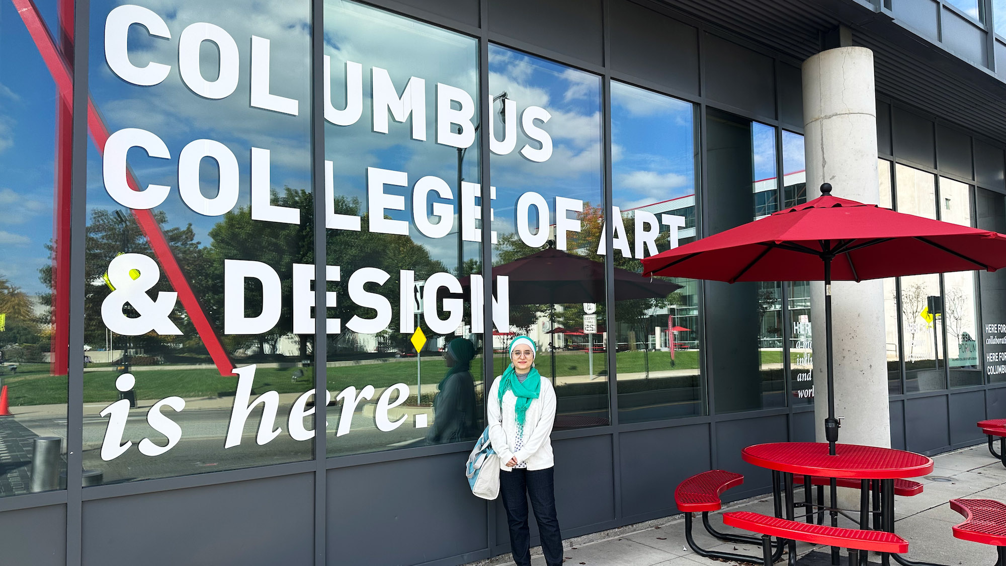 Yara standing outside the window of the Columbus College of Art and Design