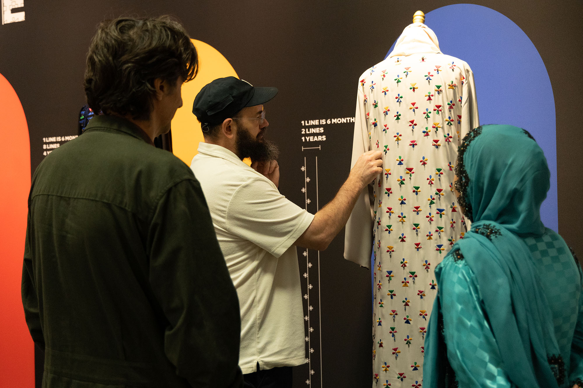 An exhibition visitor looking at one of the designs by Somaia