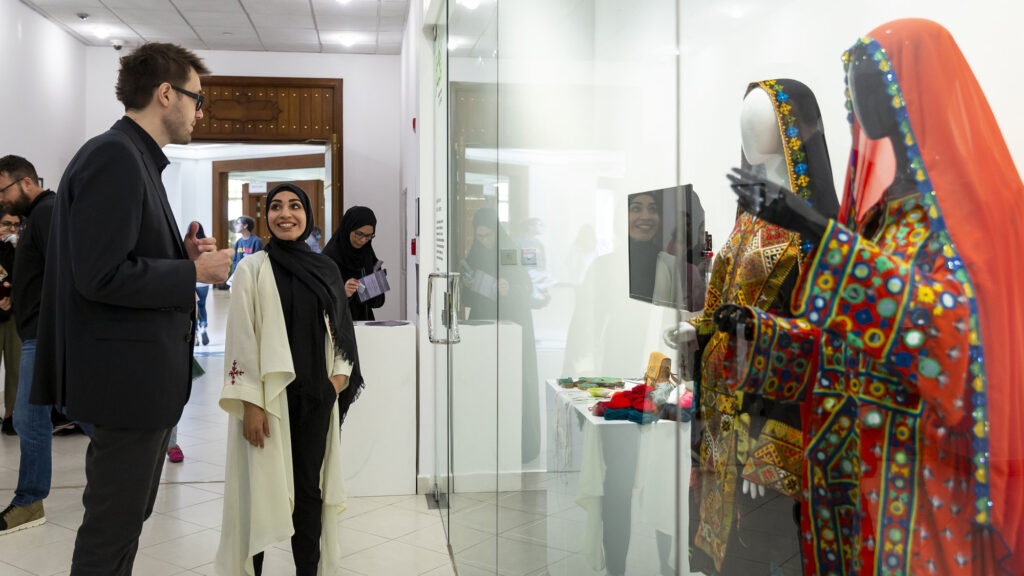 Dean Amir and Art an History student discussing one of the student's projects at an exhibition of her work