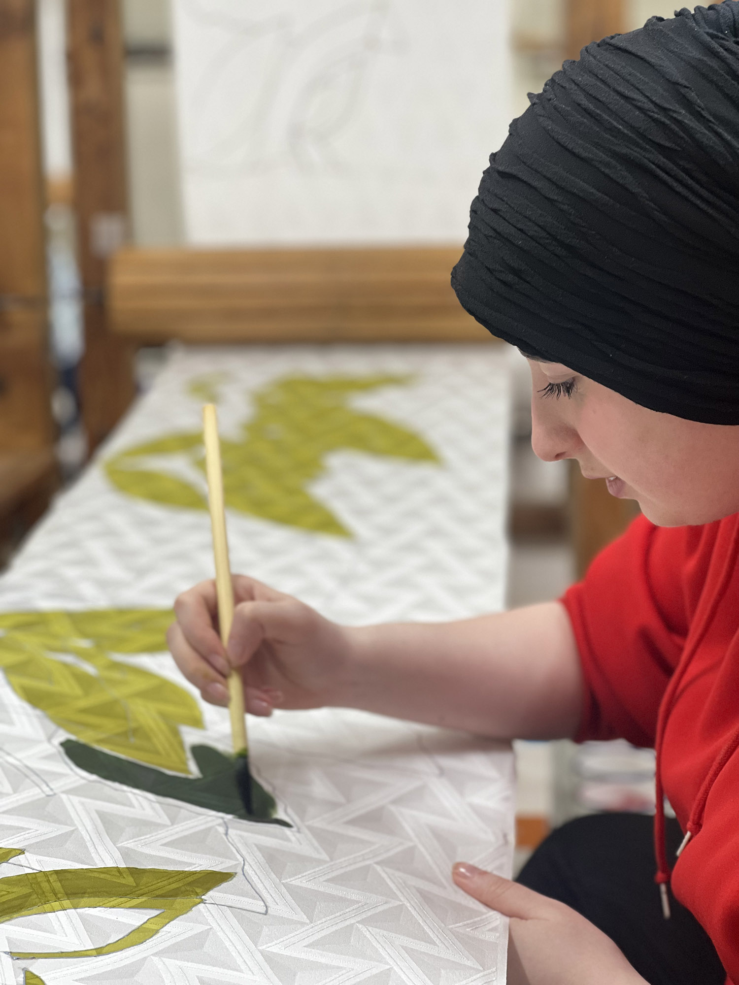 A student using ink to draw on silk