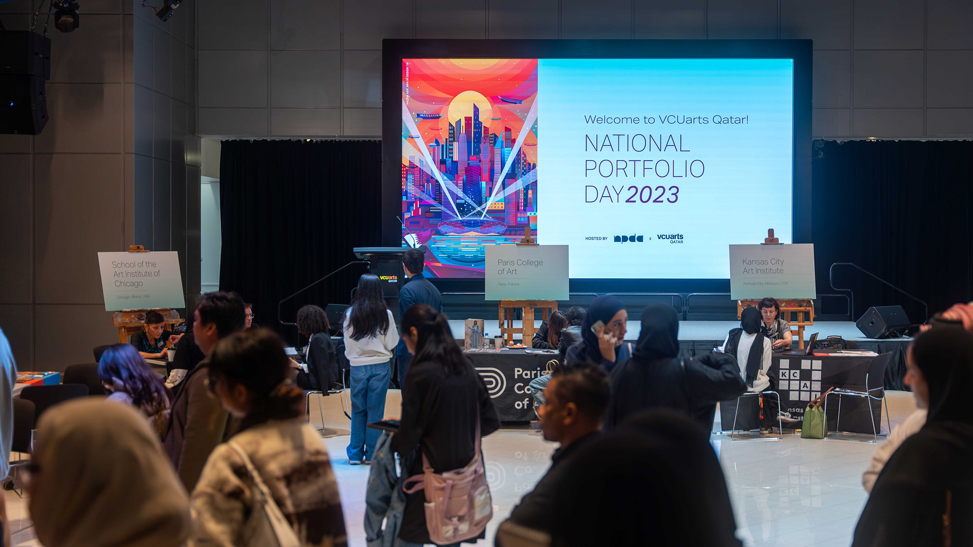 the National Portfolio Day event at the Atrium with the attendees in the foreground and the National Portfolio Day logo on the screen in the background