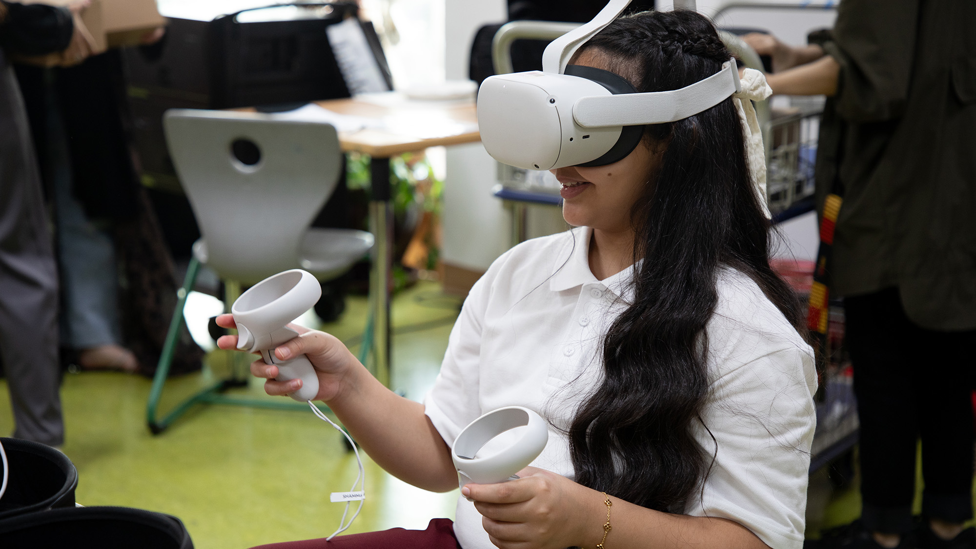 A Qatar Academy student using a virtual reality headset and paddles during the class