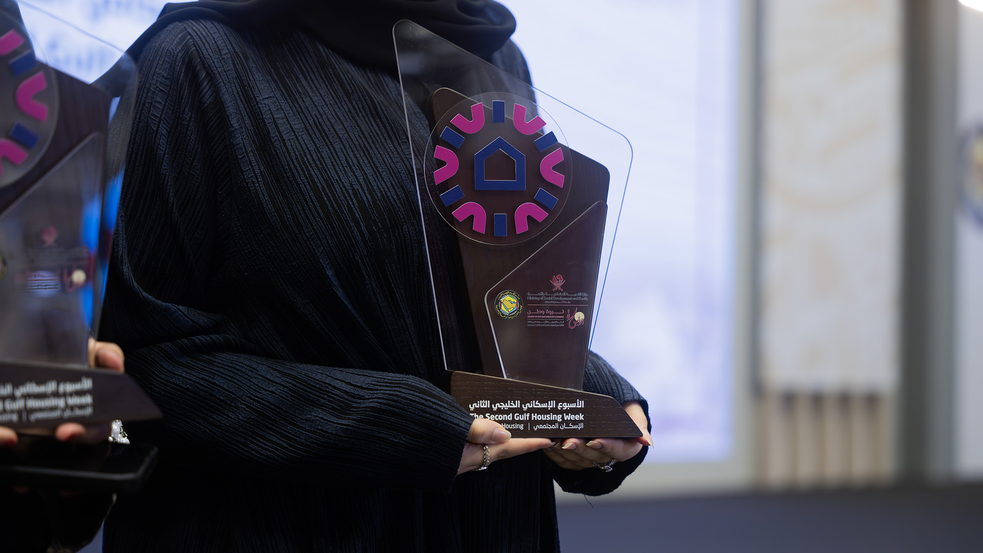 a student holding a build your home award trophy