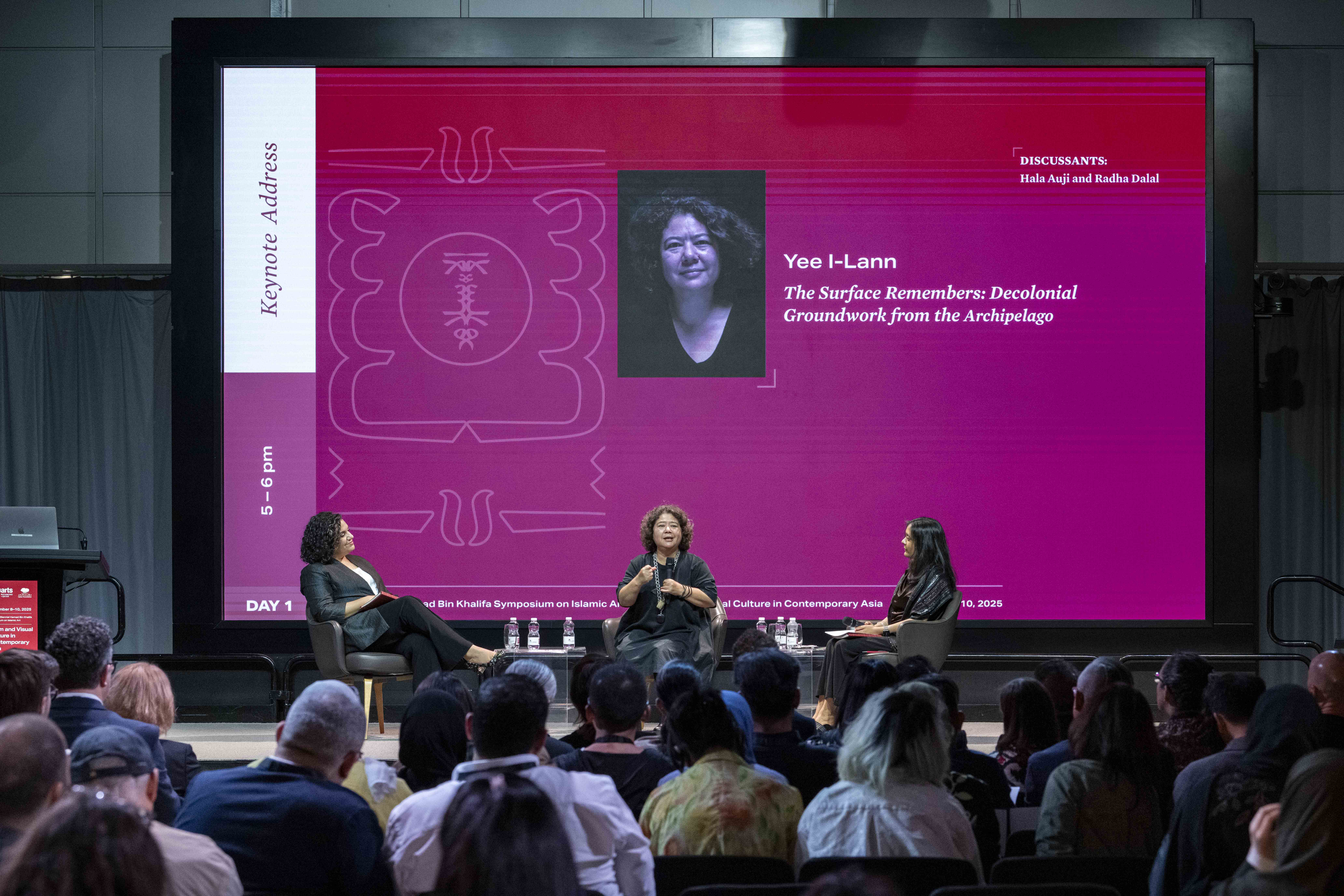 Three speakers as part of a panel discussion talking while on stage