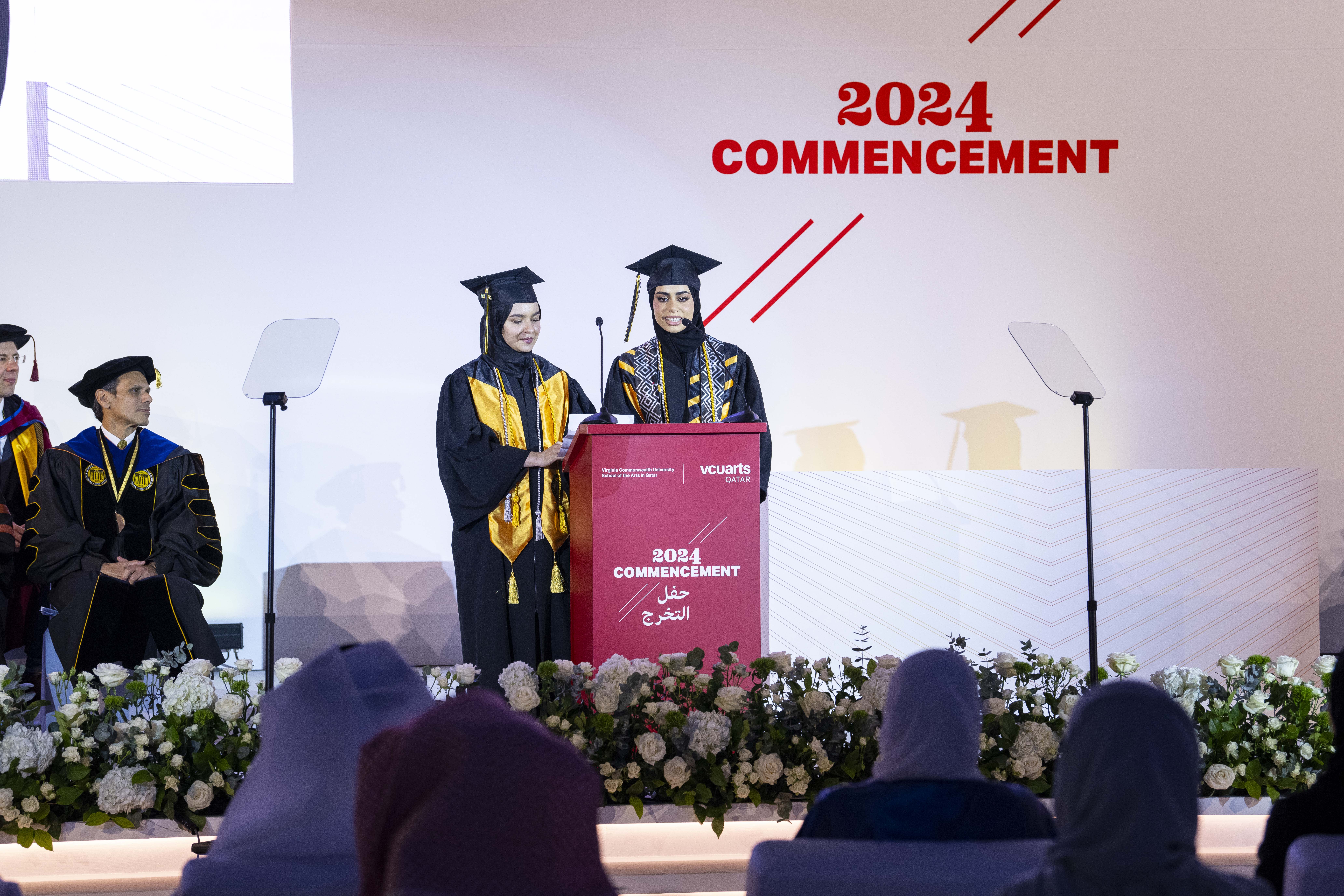 Two students speaking on stage during commencement