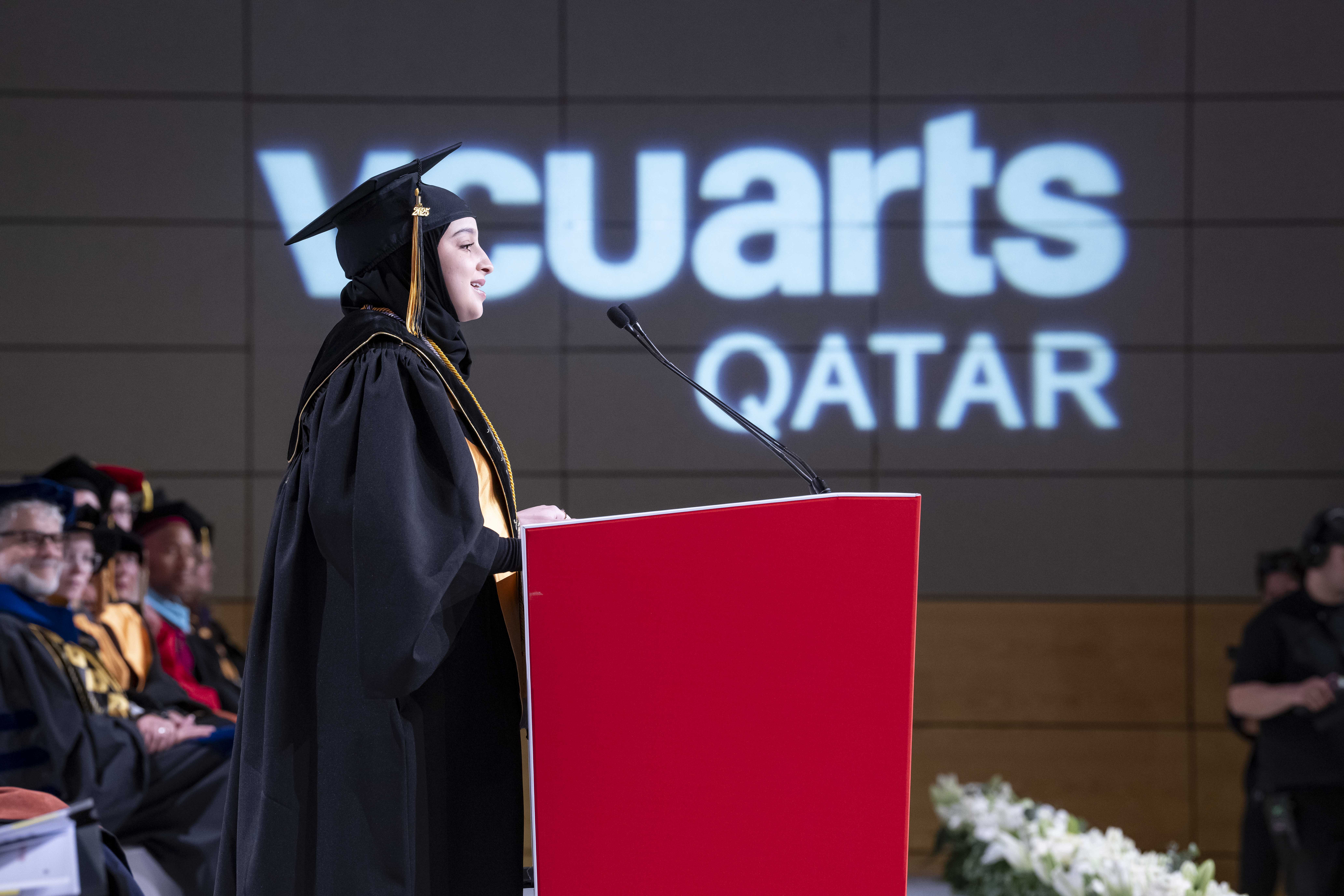 Student speaking on a podium during commencement.